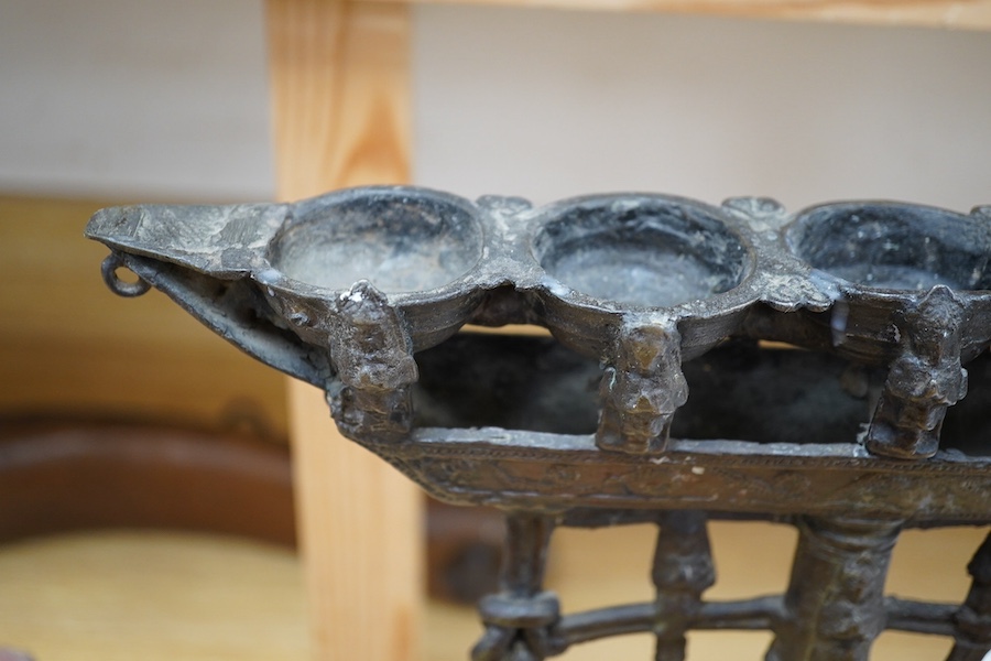 An 18th/19th century Indian Buddhist bronze oil lamp, on a later wood stand, 42.5cm high. Condition - fair